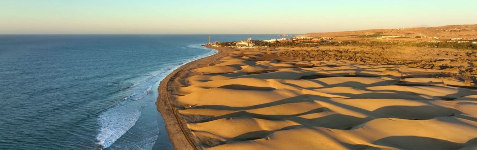Dunas de Maspalomas con vista aérea al atardecer junto al océano Atlántico en Gran Canaria, España