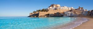 Castillo medieval de Peñíscola sobre acantilado con aguas turquesas del Mediterráneo en Castellón, España